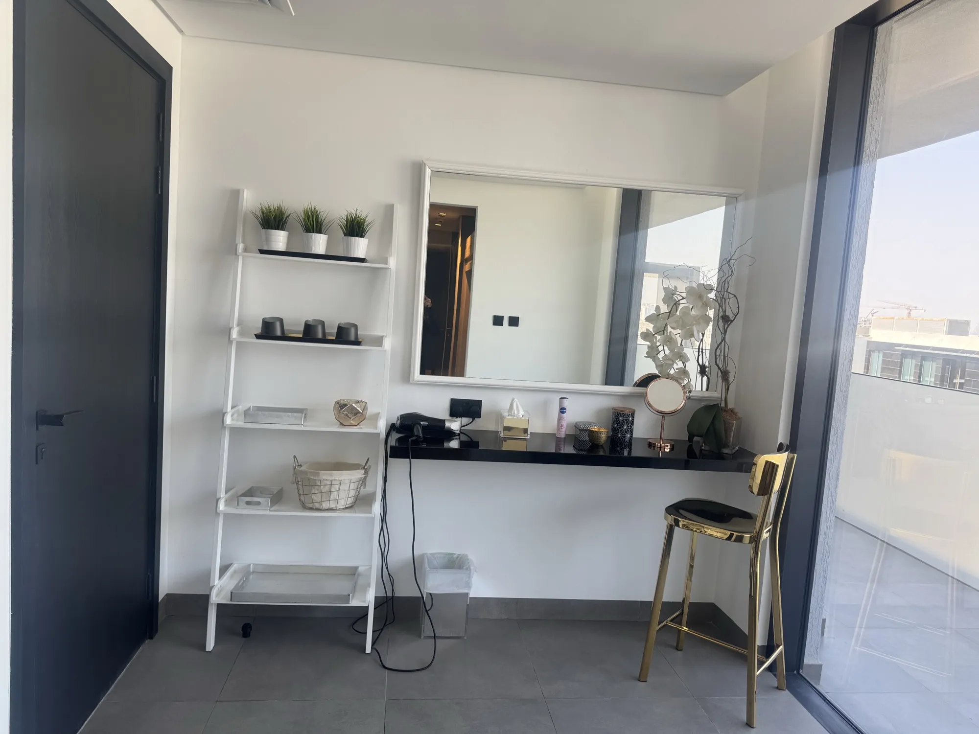 Changing room vanity with backlit mirror and dark stone counter