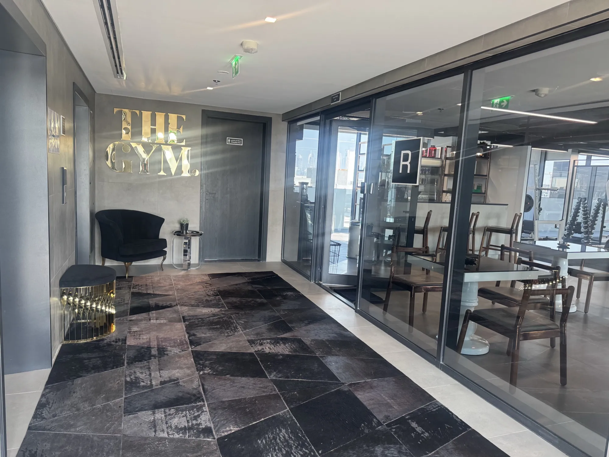 Reception lobby with the gold Gym logo and stone floor